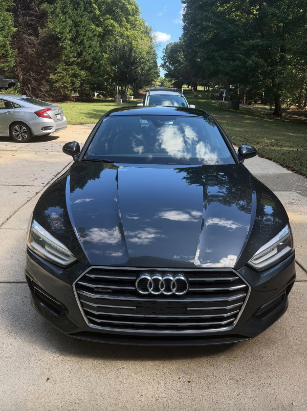 Black Audi A5 showing mirror-finish paint reflection
